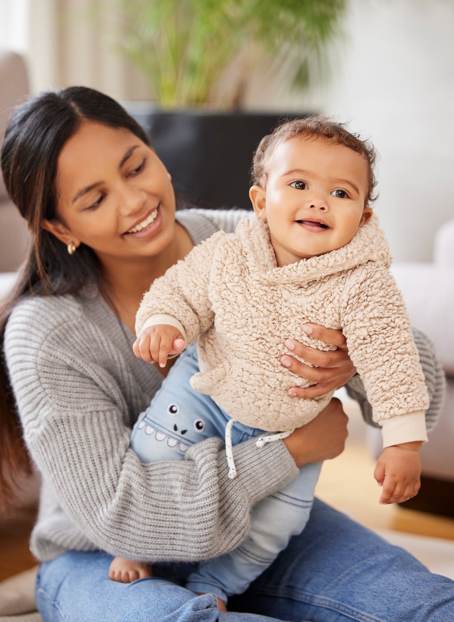 A young Hispanic mother holding her infant child for interactive developmental playtime